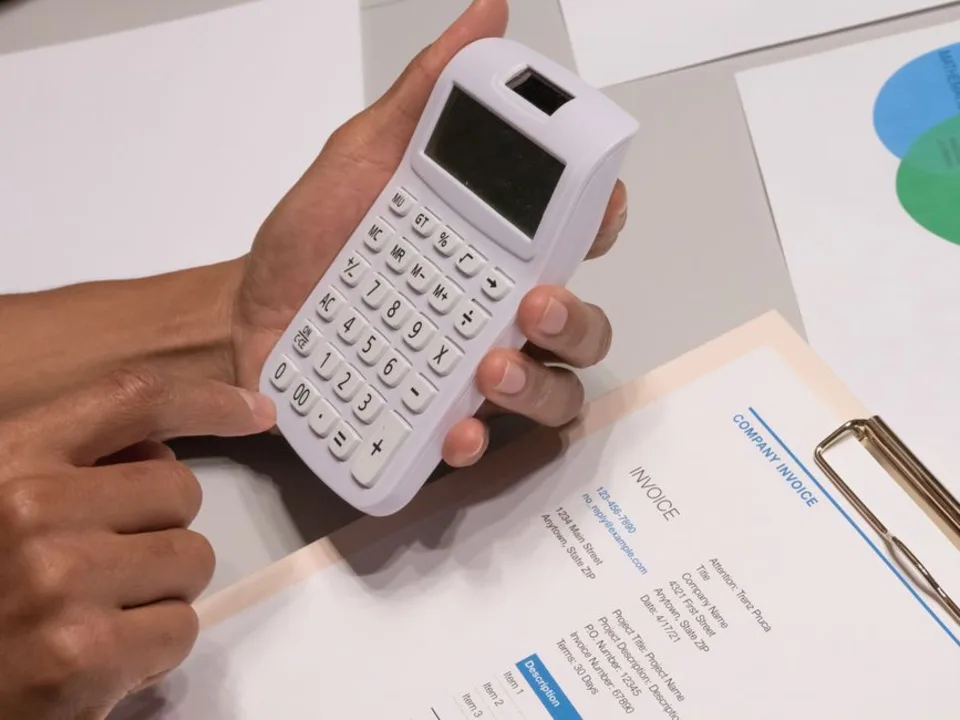 Analista financiero revisando facturas y documentos de cartera comercial