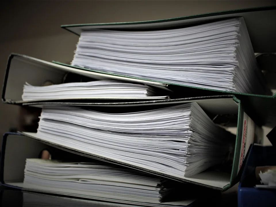 Carpetas y archivadores con documentos, representando los manuales de prevención de LA/FT/FPADM en Ecuador
