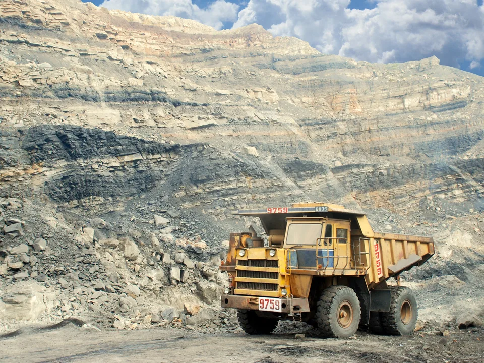 Camión de gran tonelaje operando en una cantera de minería a cielo abierto entre terreno rocoso