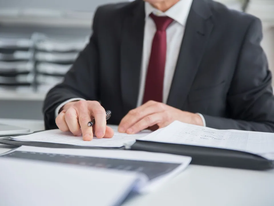 Profesional revisando documentos e informes financieros como oficial de cumplimiento