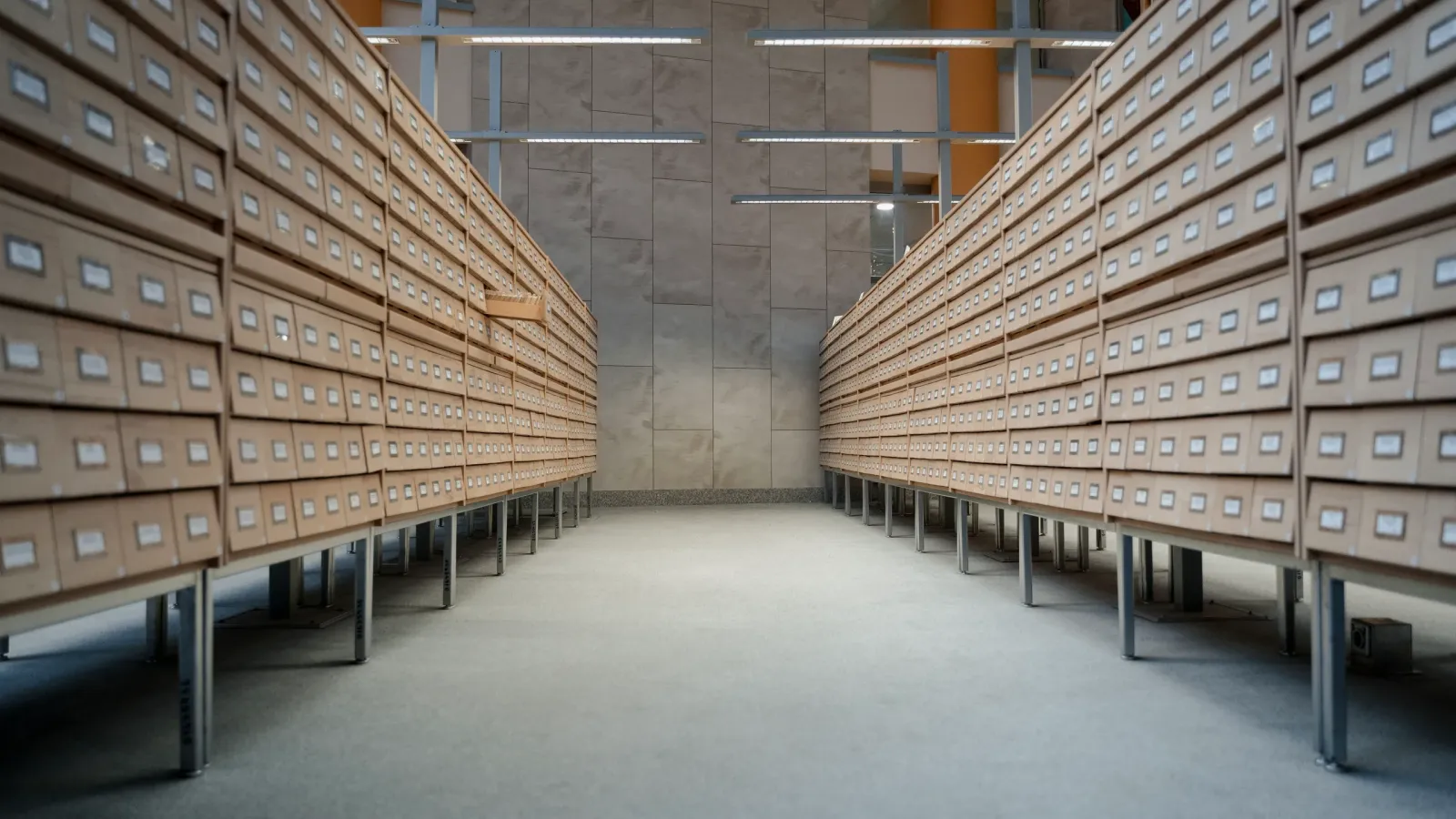 Archive room with long rows of wooden drawers for documents, with no people