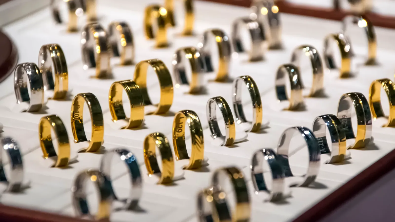 Display tray with rows of gold and silver rings in a jewelry store