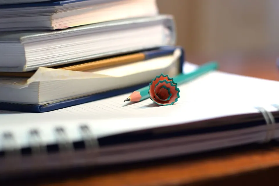 Libros, cuaderno y apuntes del programa sobre una mesa de estudio