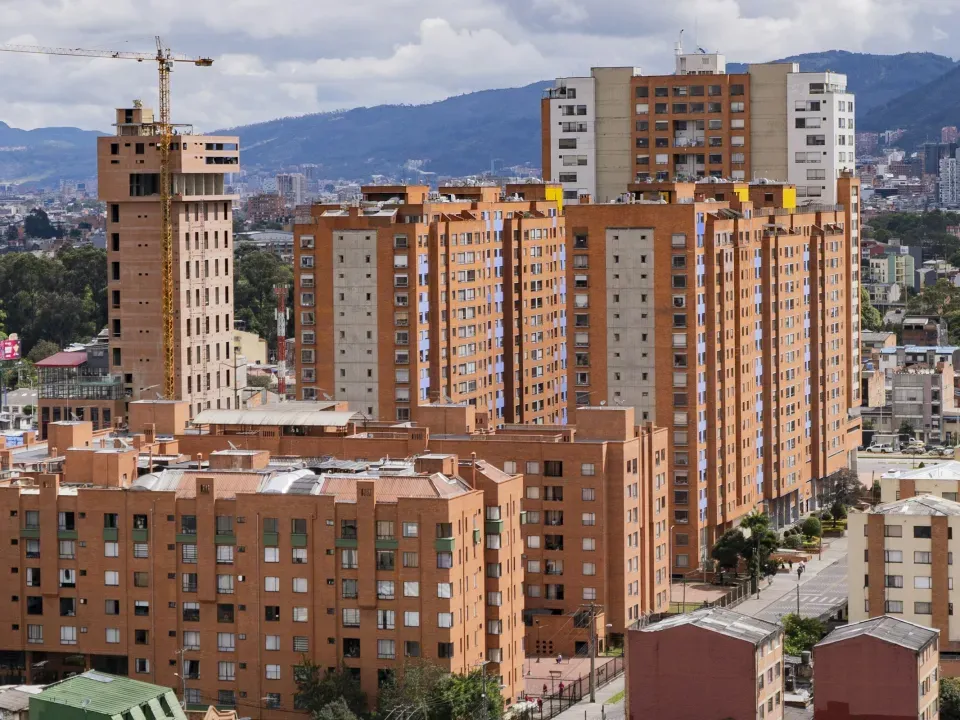 Edificios residenciales de ladrillo y una torre en construcción con grúa en Bogotá