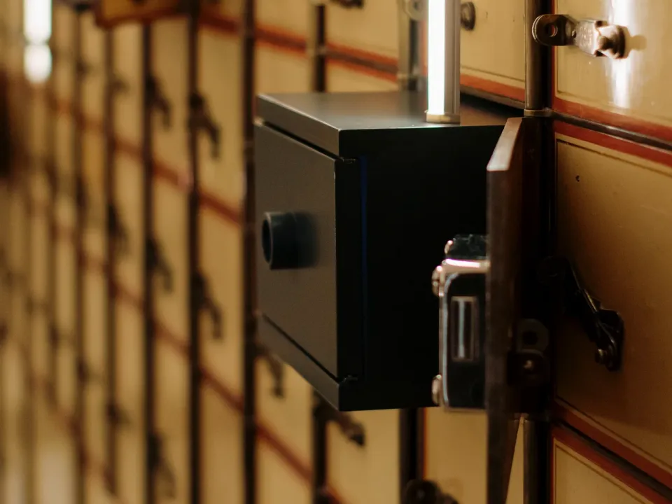 Caja de seguridad abierta en una bóveda con hileras de cajas de custodia numeradas