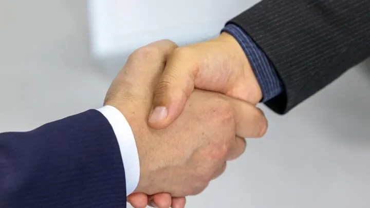 Handshake between professionals, symbolizing the corruption risk associated with Politically Exposed Persons (PEPs)