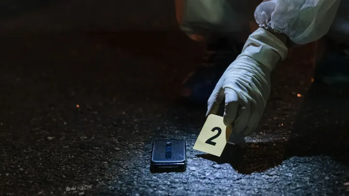 Forensic investigator collecting evidence at a nighttime scene, representing investigative work linked to cocaine trafficking